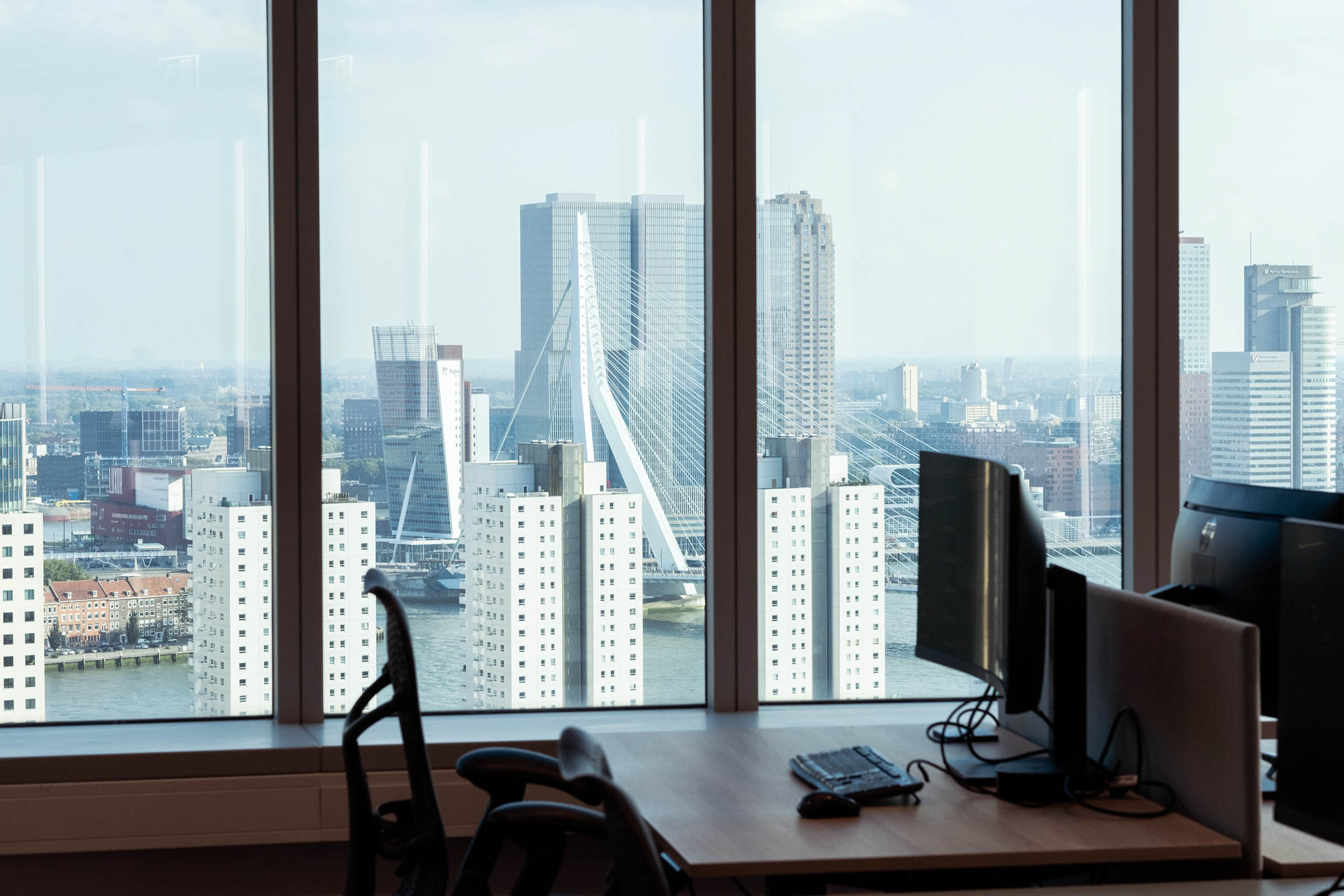 Uitzicht rotterdam erasmusbrug vanuit modern kantoor aan Blaak