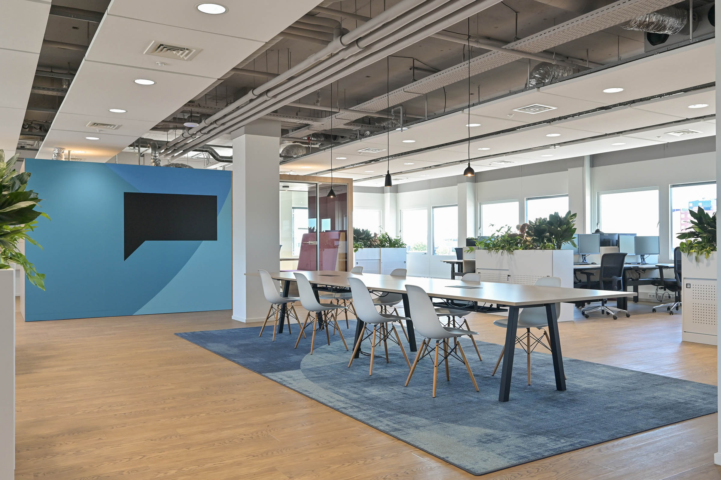 Ege vloerkleed blauw in modern kantoor met overlegbooth en aanlandtafel waar agile gewerkt kan worden