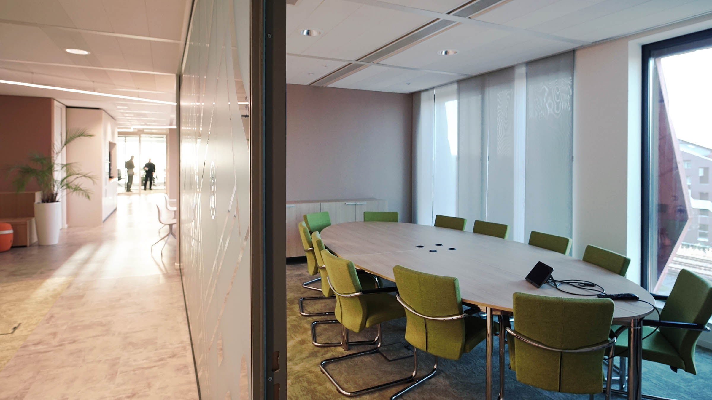 Speelse vergaderruimte met groene stoelen in warme omgeving