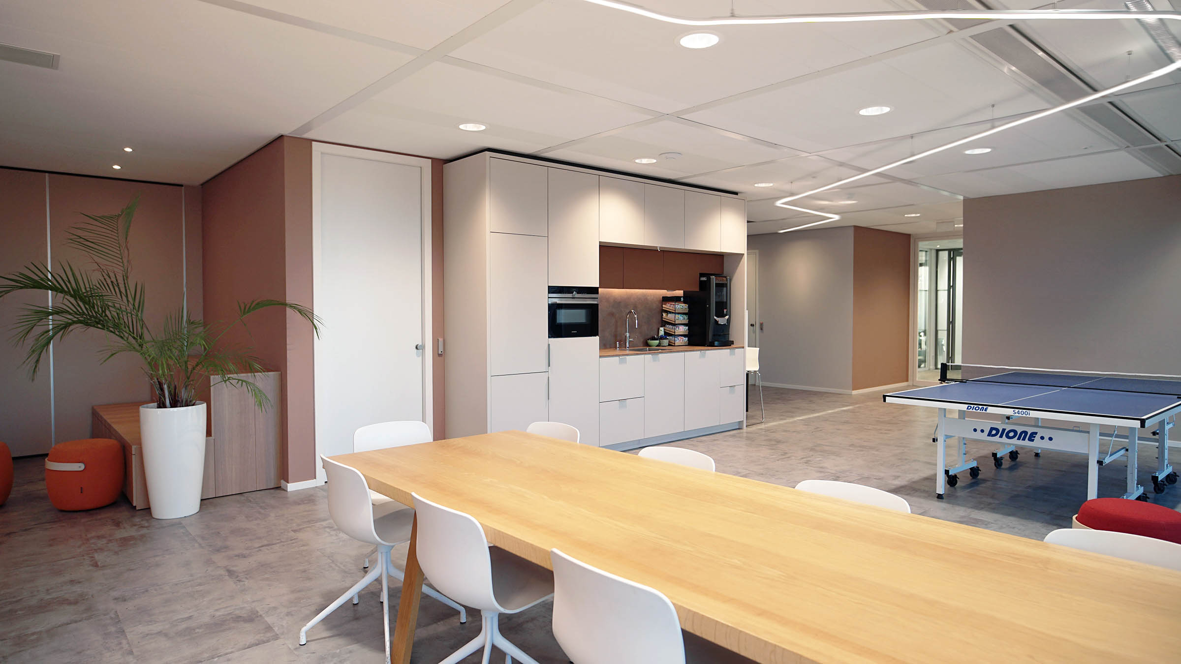 Pingpong tafel en coffee corner in lunchruimte van modern kantoor met LED lijn