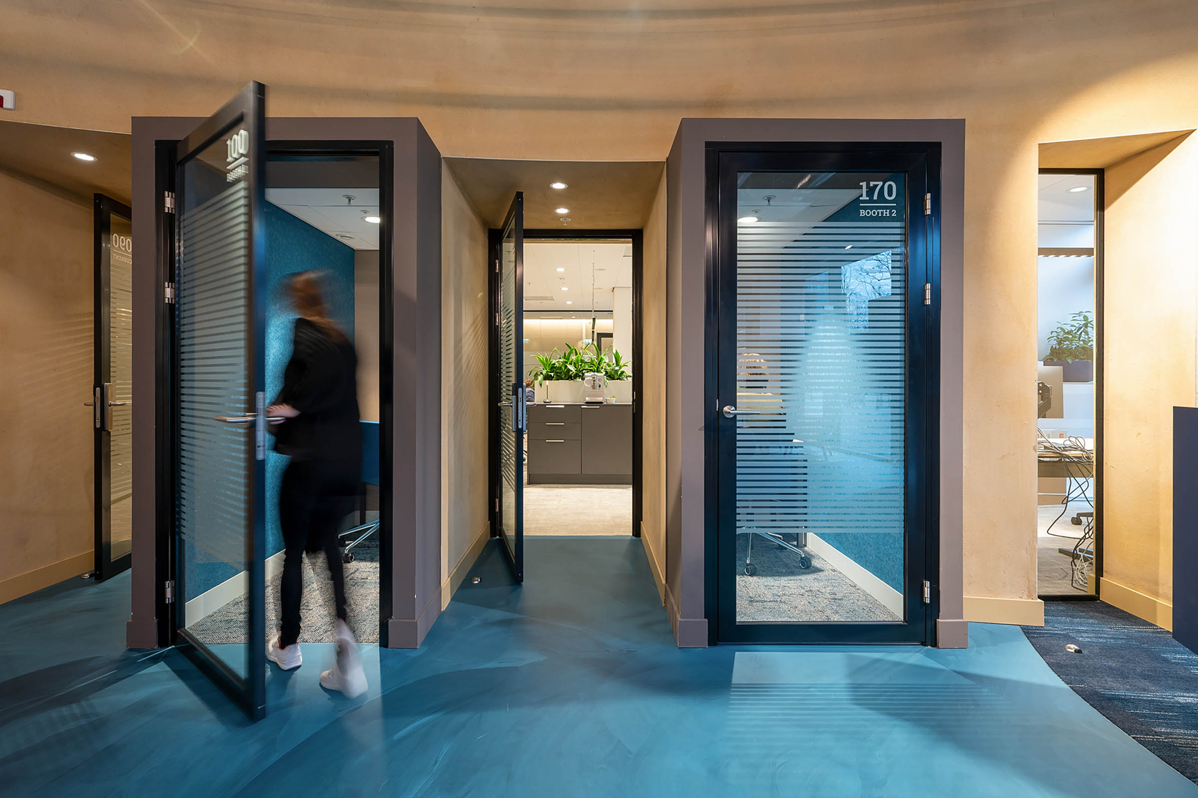 phonebooths in modern kantoor van TU Delft met blauwe gietvloer