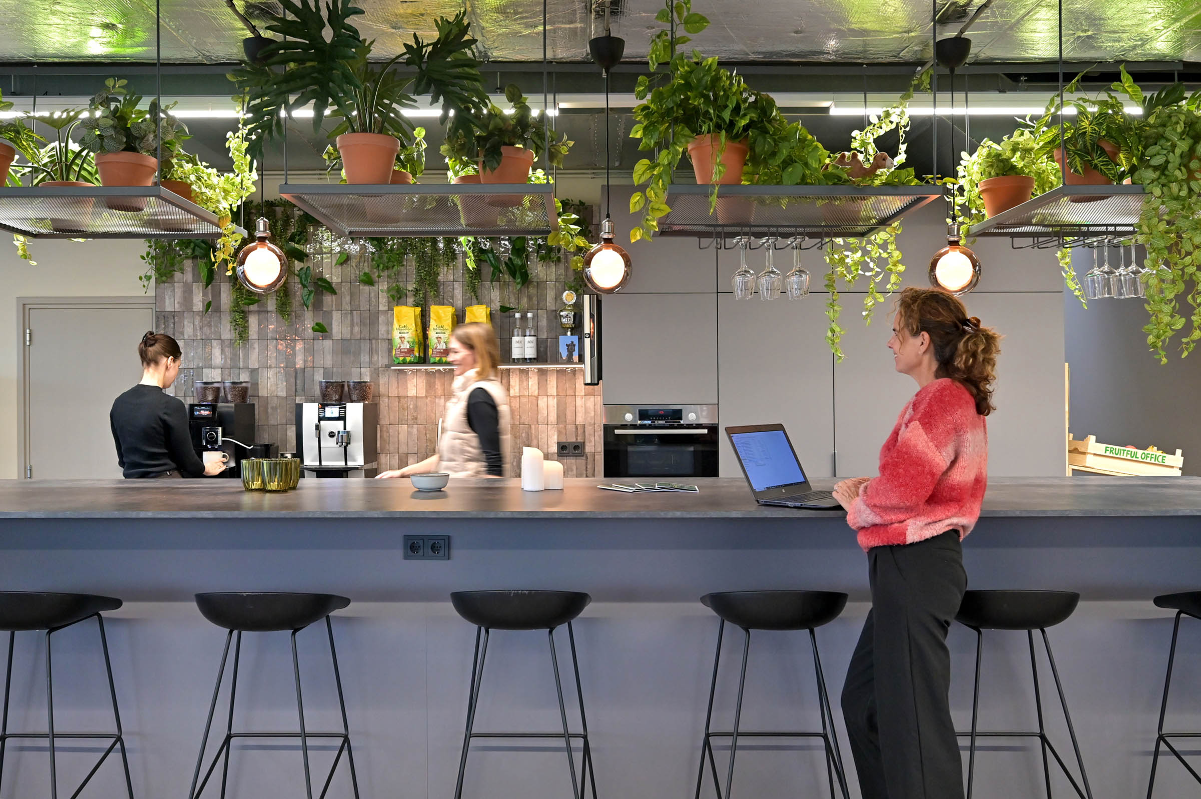 Moderne kantoorruimte met eiland, koffie corner en hangplanten boven bar
