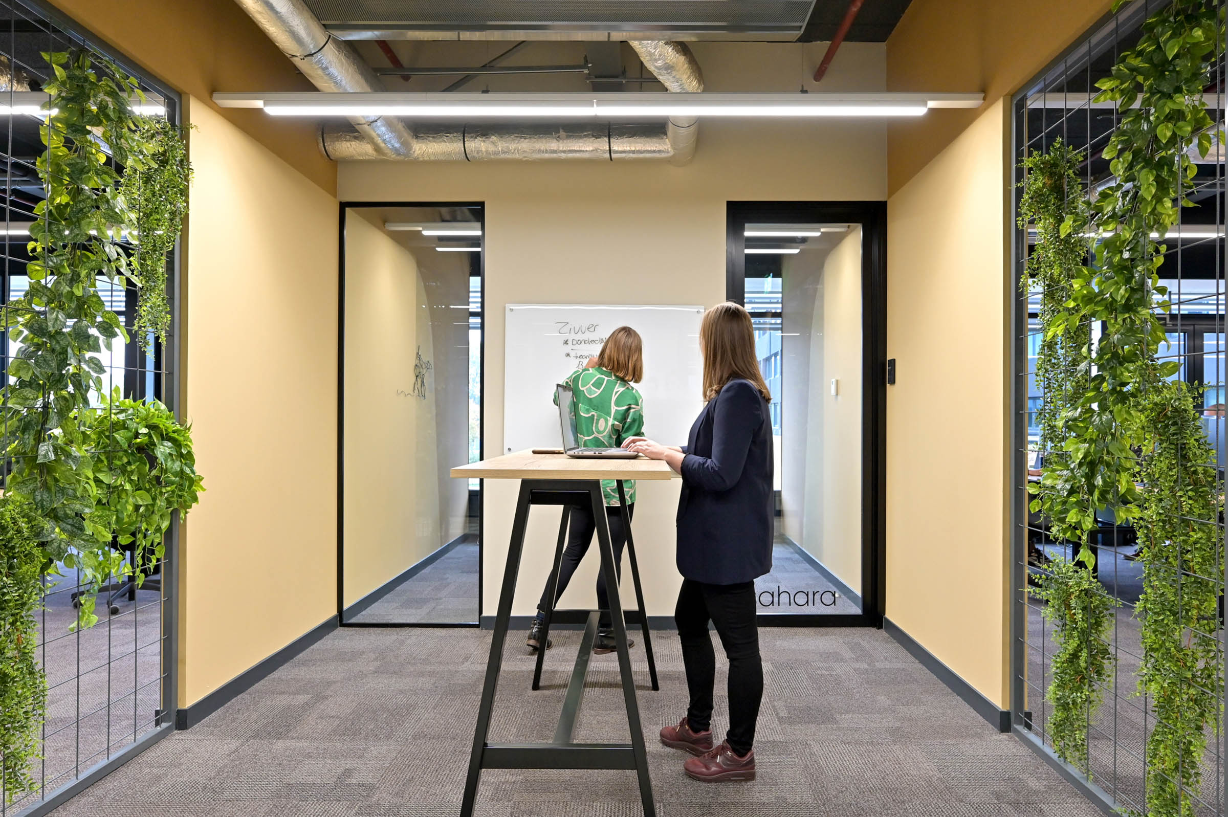 Moderne kantoorruimte met sta tafel waar agile gewerkt kan worden, groene planten in industriele omgeving