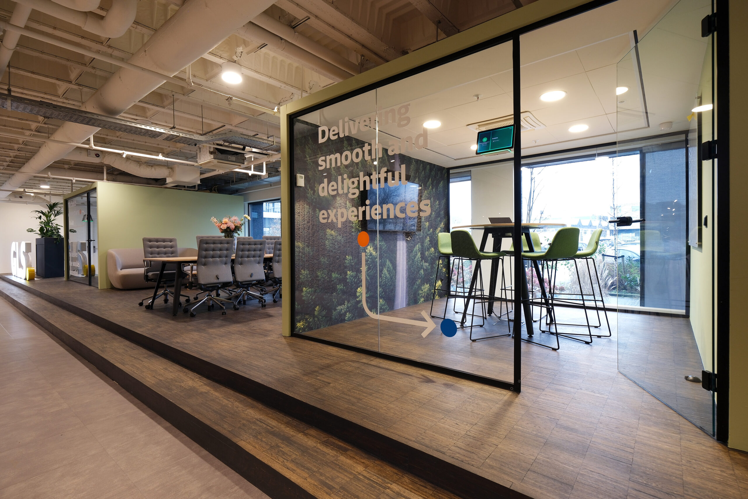 Entree modern en industrieel kantoor van GLS in Amsterdam met werkplek en staand vergadertafel